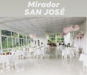 A spacious indoor venue with white tables and chairs, large windows, and a ceiling with a grid pattern. - Hotel mirador San jose (Santa Rosa de Cabal)