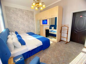 Een slaapkamer met een groot bed, een televisie, een kledingkast en een spiegel.
