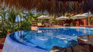 A clear blue infinity pool with lounge chairs and umbrellas, surrounded by palm trees and a thatched roof structure. - March Break Mexico Getaway
2 Bedroom Beach front Vacation Home
Sleeps 6 (Zihautanejo)