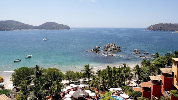 A coastal view with a beach, palm trees, and a rocky outcrop in the water. - March Break Mexico Getaway
2 Bedroom Beach front Vacation Home
Sleeps 6 (Zihautanejo)
