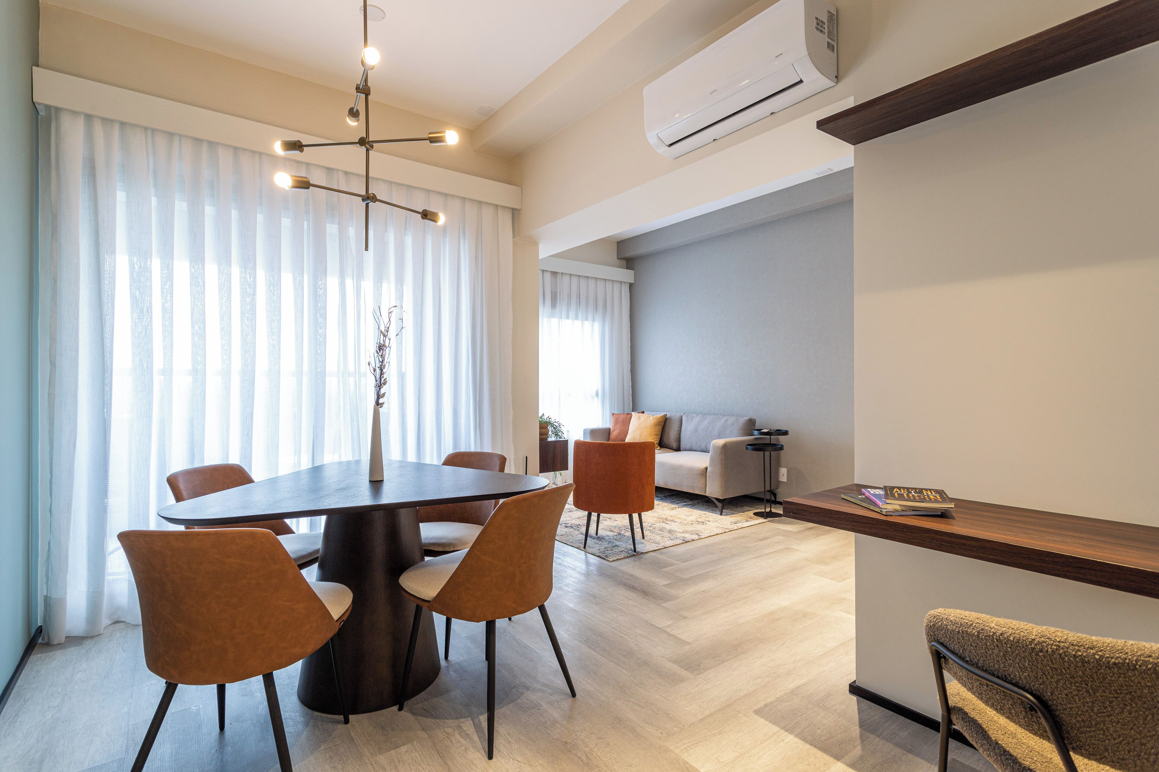 A modern living room with a dining area, featuring a round table, chairs, a sofa, and a coffee table.