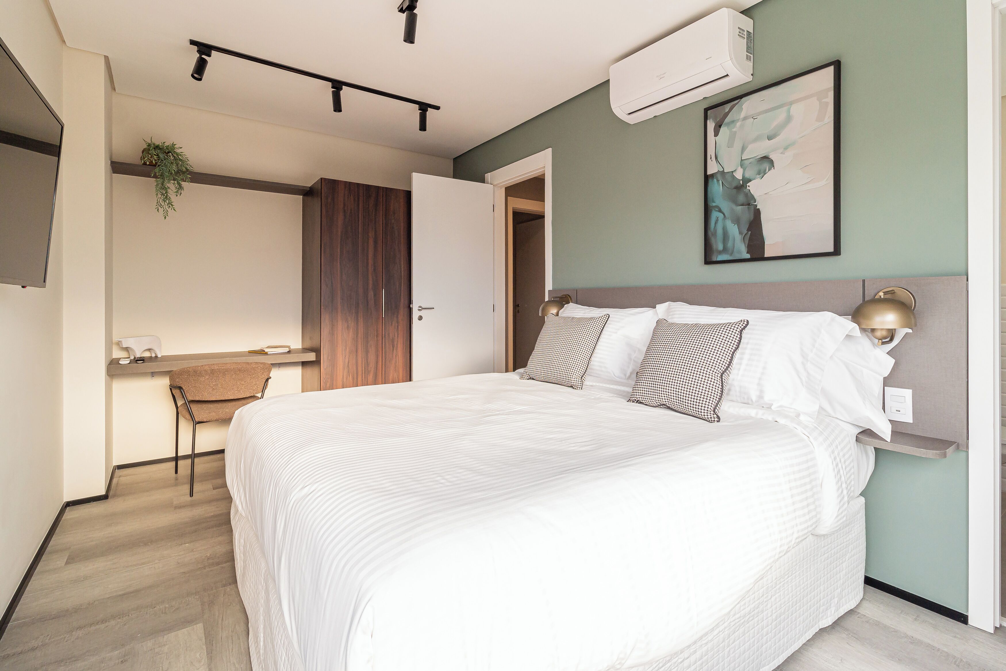 Une chambre moderne avec un grand lit, un bureau et une chaise.