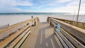 A wooden boardwalk leading to a sandy beach with a clear sky. - "Seaside Bliss: Beachfront Condo with Stunning Ocean-View Balcony!" (Orange Beach)