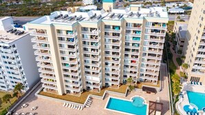 A multi-story hotel with balconies, a swimming pool, and a rooftop area. - "Seaside Bliss: Beachfront Condo with Stunning Ocean-View Balcony!" (Orange Beach)