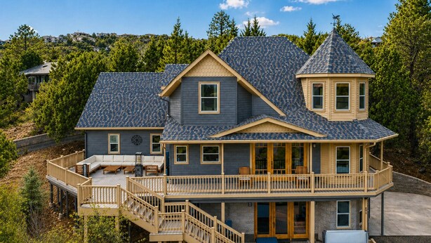 Une maison à deux étages dotée d’un balcon, d’un jacuzzi et d’une terrasse.