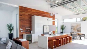 Uma cozinha moderna com ilha central, armários brancos e detalhes em madeira.