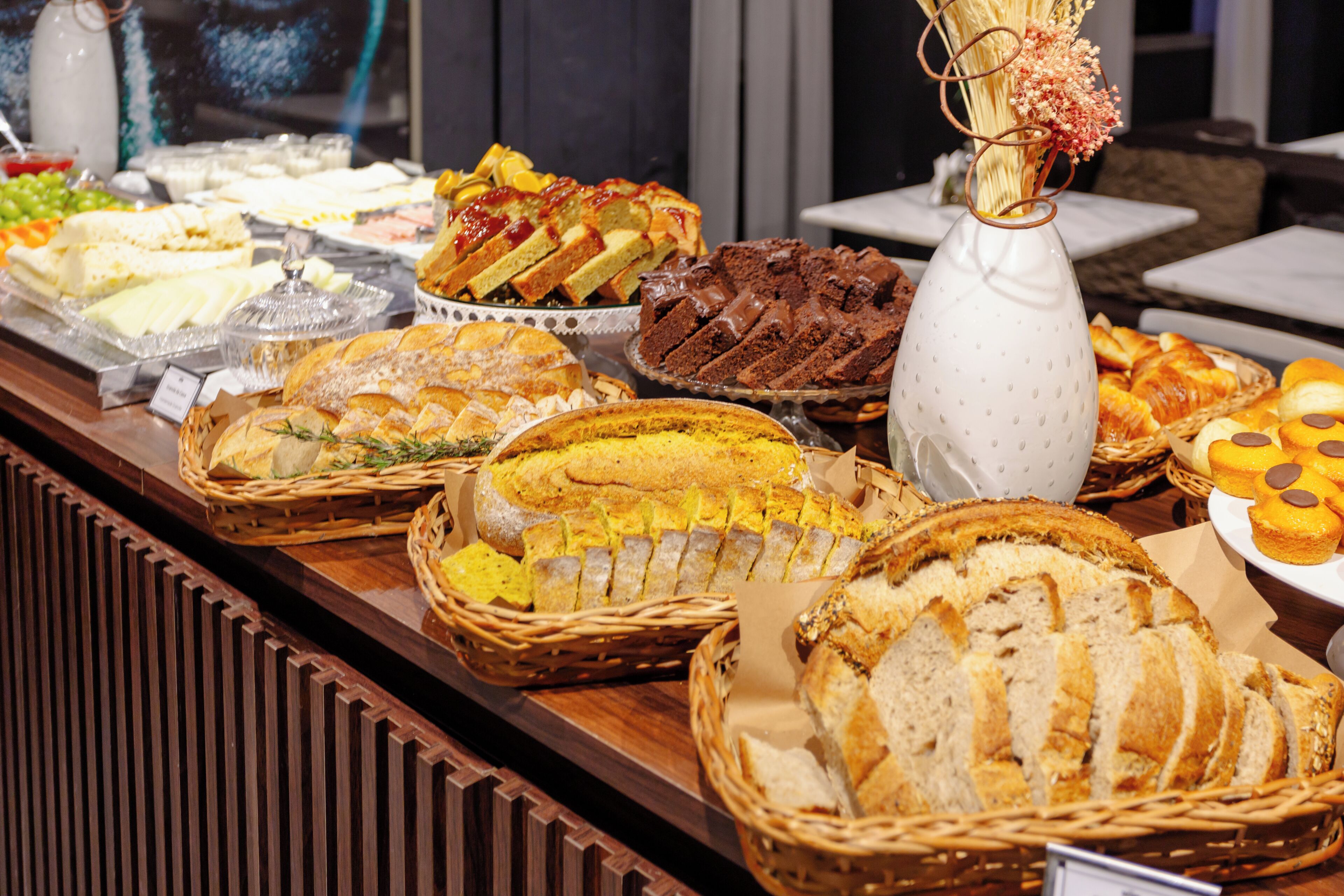 Un buffet con diverse portate, tra cui pane, pasticcini e dolci.