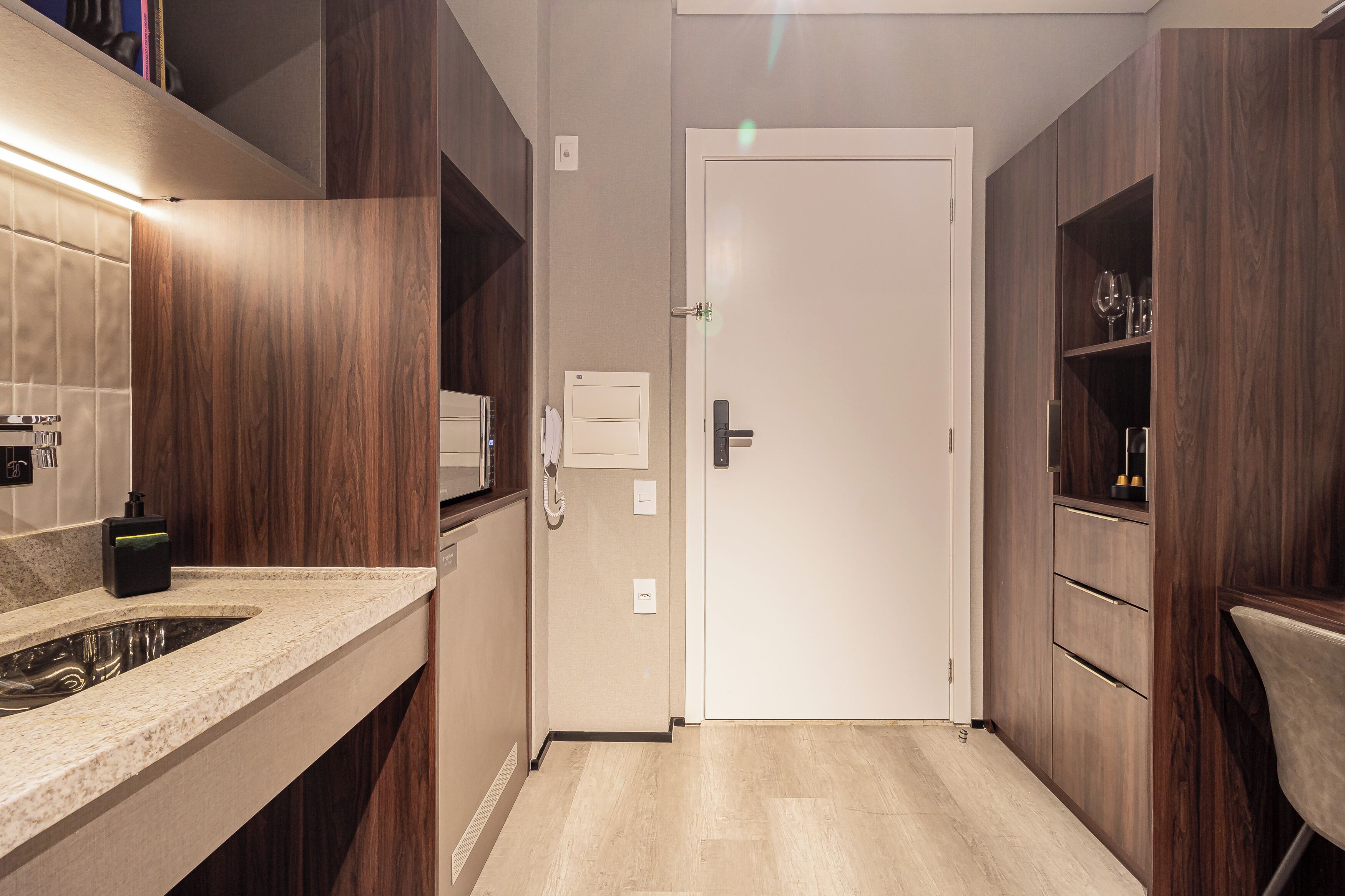 Un baño moderno con lavamanos, espejo y armarios de madera.