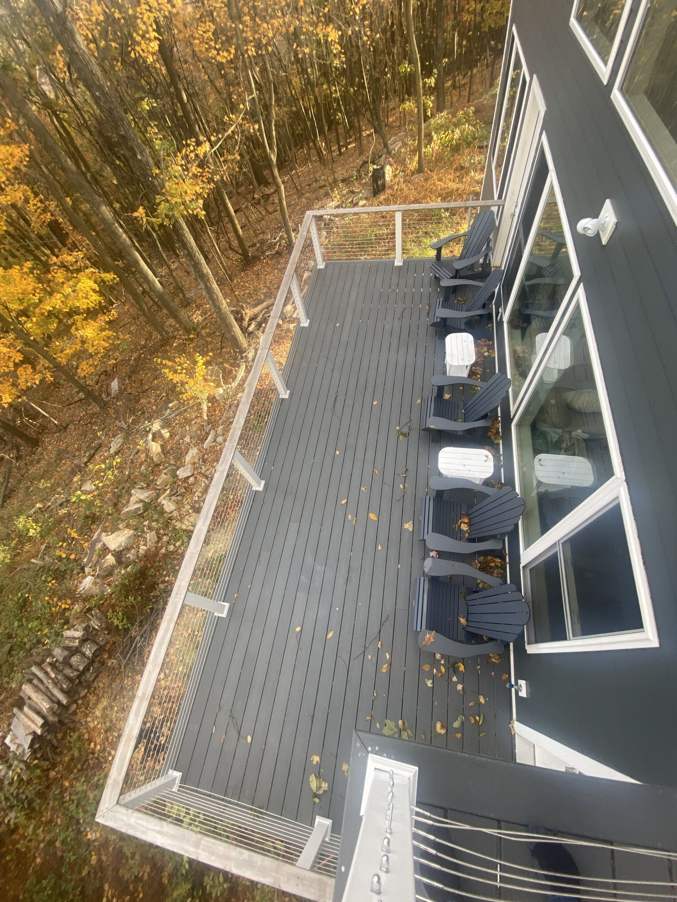 A deck with outdoor seating and a view of a forest.