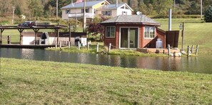 Une propriété située au bord de la rivière, comprenant un petit quai, une maison et un chalet.