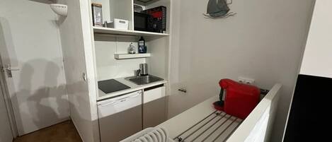 A compact kitchen with a built-in dishwasher, a small sink, and a microwave.