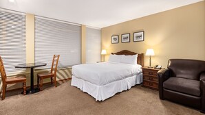 A hotel room with a bed, a desk, two chairs, a dresser, and a lamp. - Cascade Lodge suite ski/bike storage room WIFI pool 2 hot tub sauna gym cable TV (Whistler)
