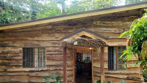 A rustic log cabin with a wooden porch and a sign that reads "Julia".