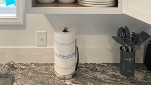 A kitchen with a wooden cabinet containing stacked plates and bowls. - Cozy Country home just 5 miles to Boyne City/8 miles to Boyne Mountain (Boyne City)