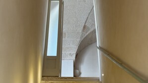 Un escalier avec un mur en pierre et une porte en haut.