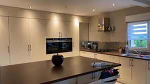 Cozinha moderna com eletrodomésticos embutidos, uma ilha grande e uma janela que traz luz natural.