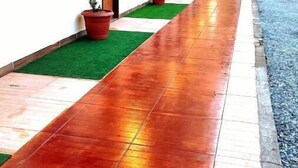 Um corredor com aparelhos de ar condicionado, plantas em vasos e piso de azulejos.