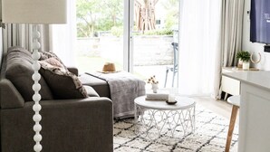 Un salon moderne avec un canapé, une table basse ronde et un téléviseur.