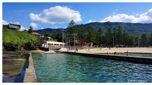 Une propriété située au bord de l’eau, dotée d’une piscine, d’une plage et offrant une vue sur les montagnes.