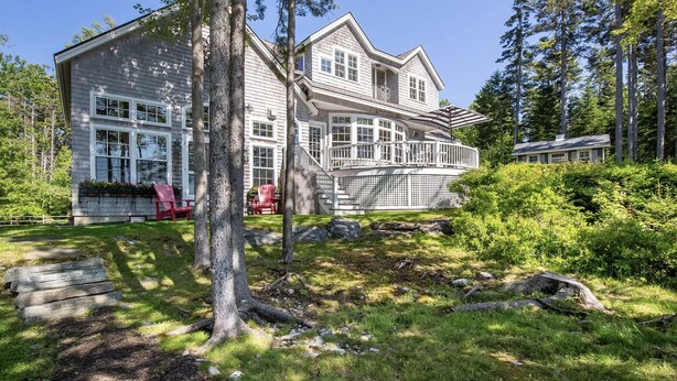 A large, two-story house with a wrap-around porch and a covered deck.