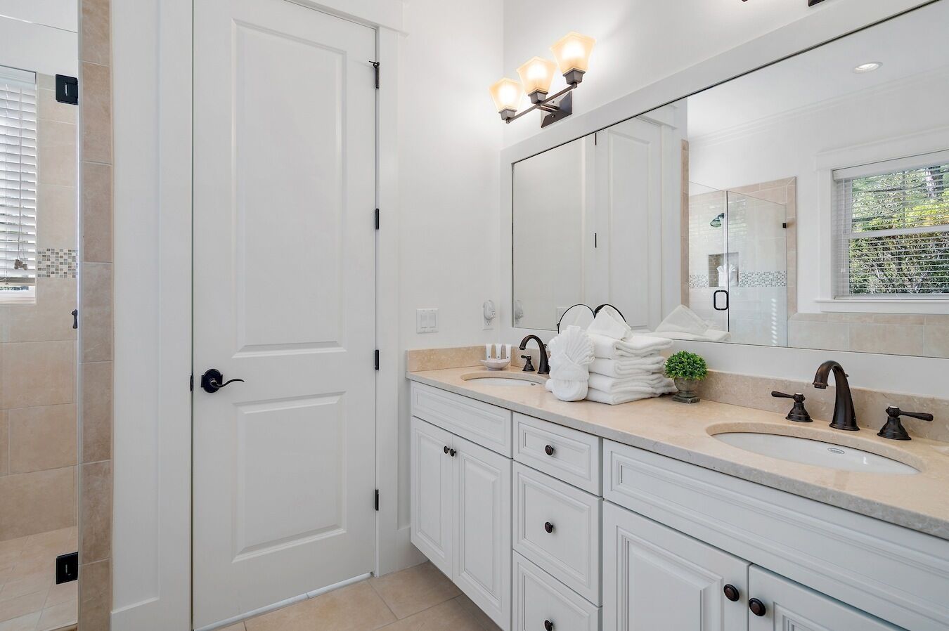 Une salle de bain moderne avec un meuble-lavabo blanc, un grand miroir et un espace douche.