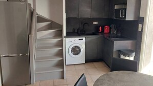 A compact kitchen with a built-in washer, a microwave, and a refrigerator. - Pretty villa T4 aircon swimming pool Rochelongue Cap d'Agde (LE CAP D AGDE)