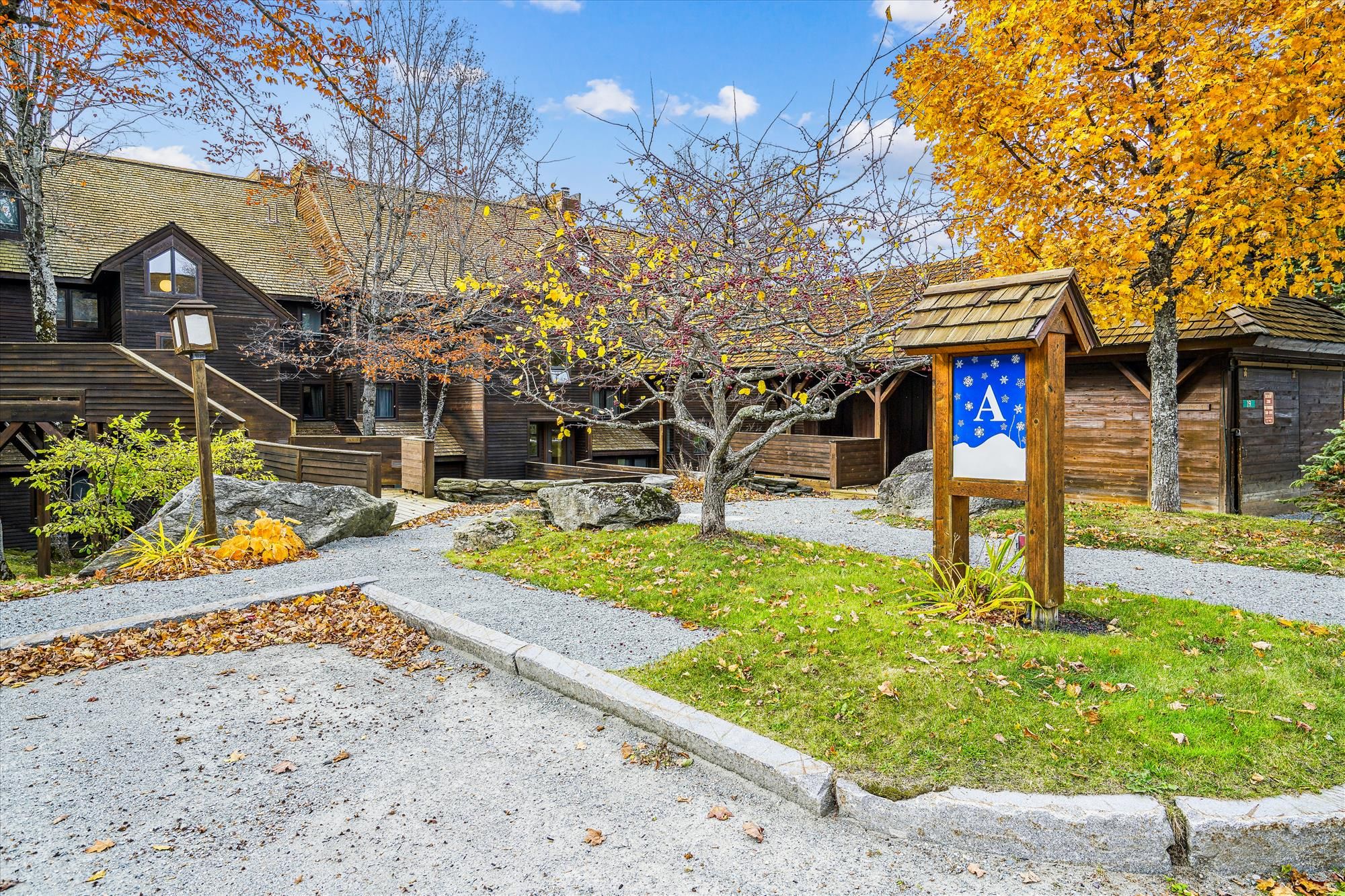 A rustic wooden building with a stone pathway leading to a wooden deck.