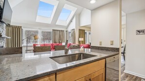 A modern kitchen with a large island, skylights, and a view of the outdoors. - Completely Renovated Three-Bedroom Condo: Your Ideal Retreat A3 (Killington)
