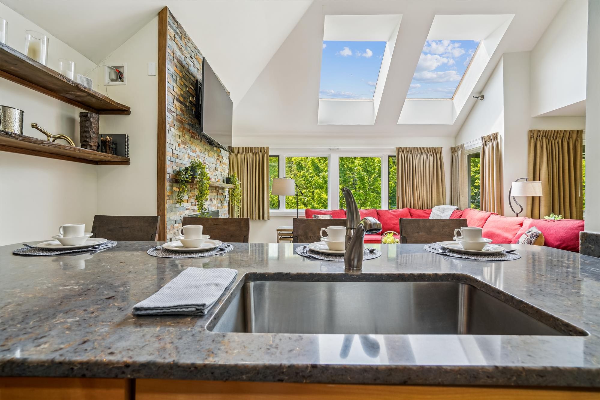 The View from the Kitchen - Prep meals while looking out to the great room, soaring skylights, and wooded views beyond.