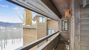 A wooden cabin with a balcony overlooking a snowy landscape. - Completely Renovated Three-Bedroom Condo: Your Ideal Retreat A3 (Killington)