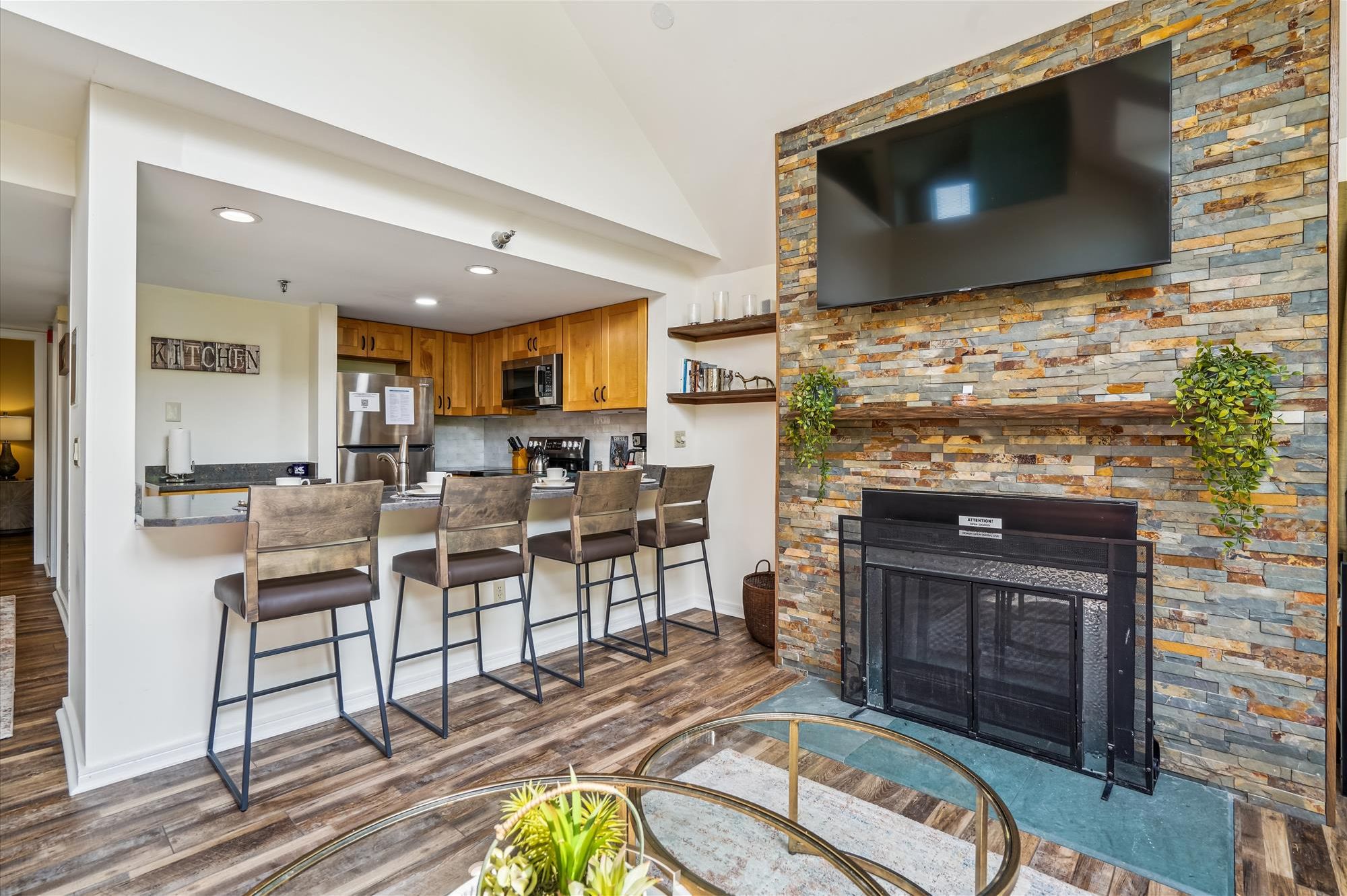Fireside Living, Mountain Style - The stone fireplace, breakfast bar, and open kitchen create the perfect space to unwind after a day outdoors.