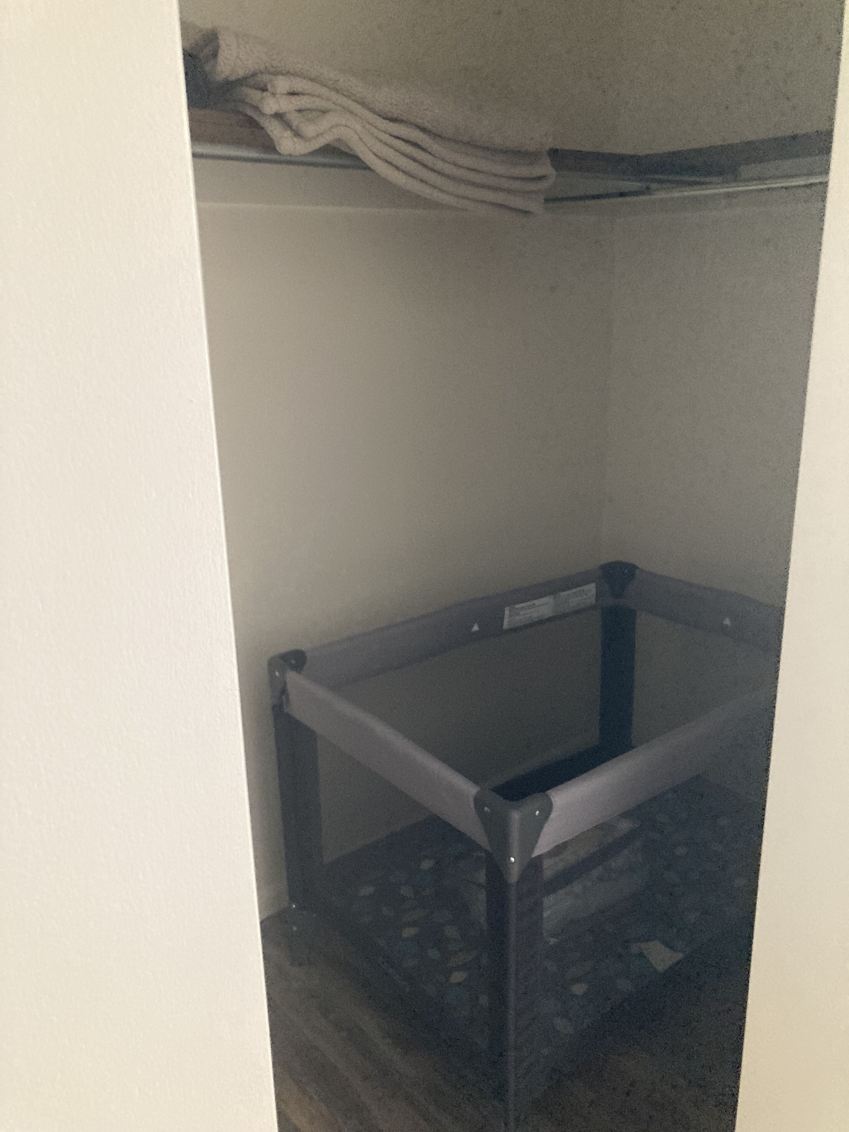 Un cuarto pequeño y cerrado, con una mesa de estructura metálica y un colchón en el suelo.