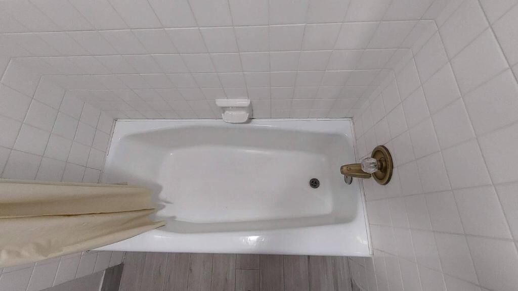 Una bañera blanca con un grifo y un jabonera.