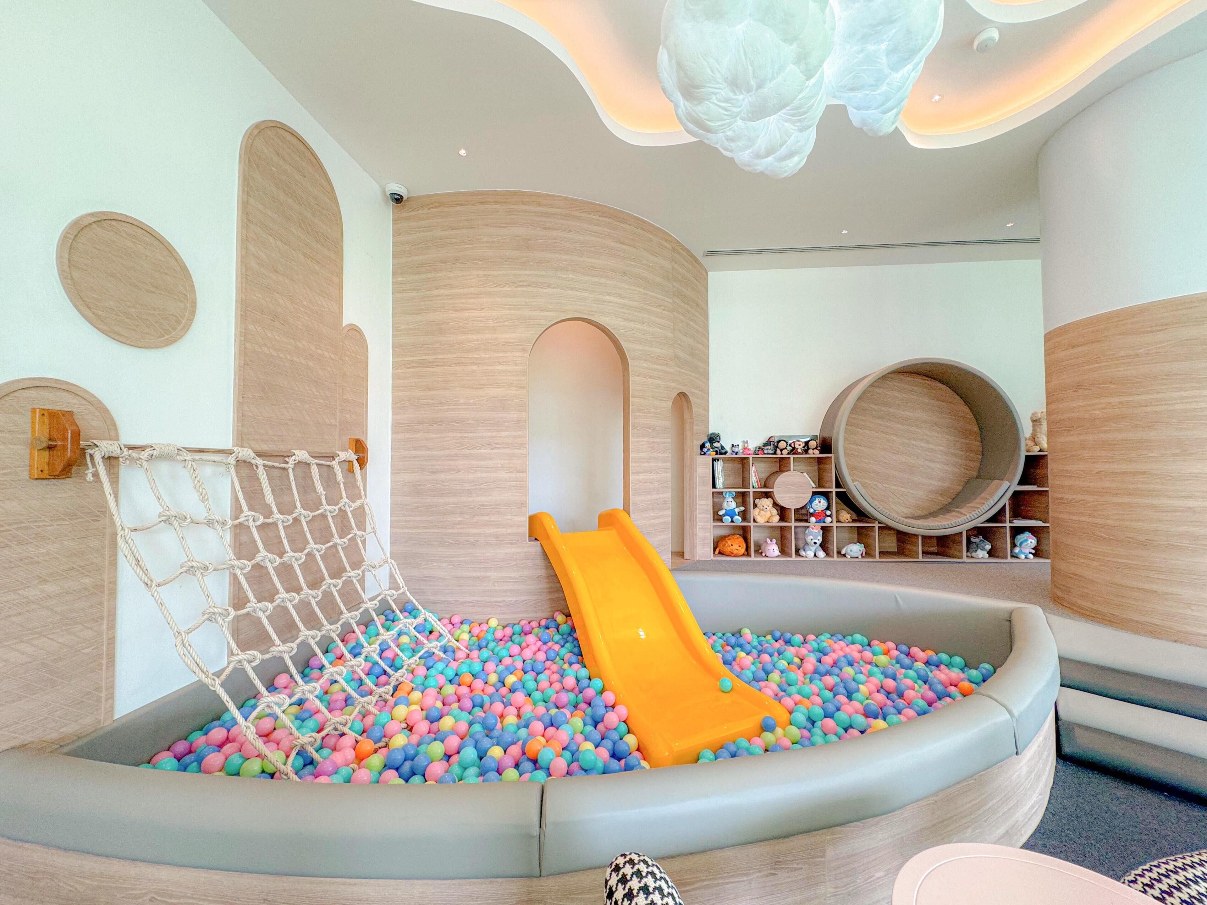 A play area with a net, slide, and ball pit.