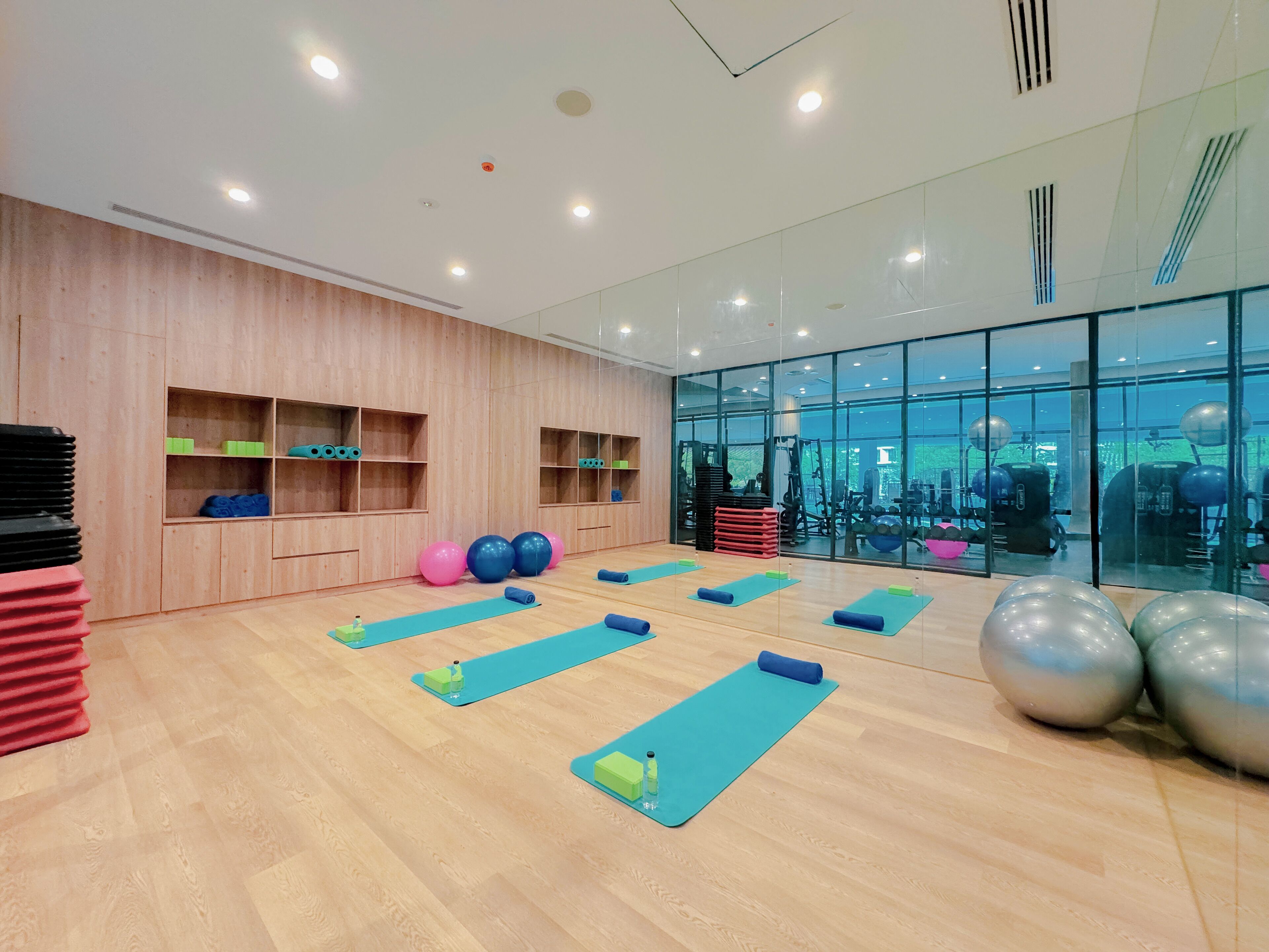 Une salle de sport spacieuse avec des murs en bois, des tapis de sol et divers équipements de remise en forme.