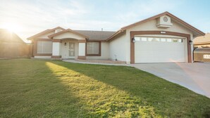 A single-story house with a garage, a front door, and a well-maintained lawn. - Game Room/ Pool  Cozy Home in Yuma (Yuma)
