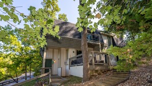A two-story house with a front porch, a staircase leading up to the entrance, and a driveway. - Seabright Sanctuary - COMFY beds - mins from Margaritaville! (Osage Beach)