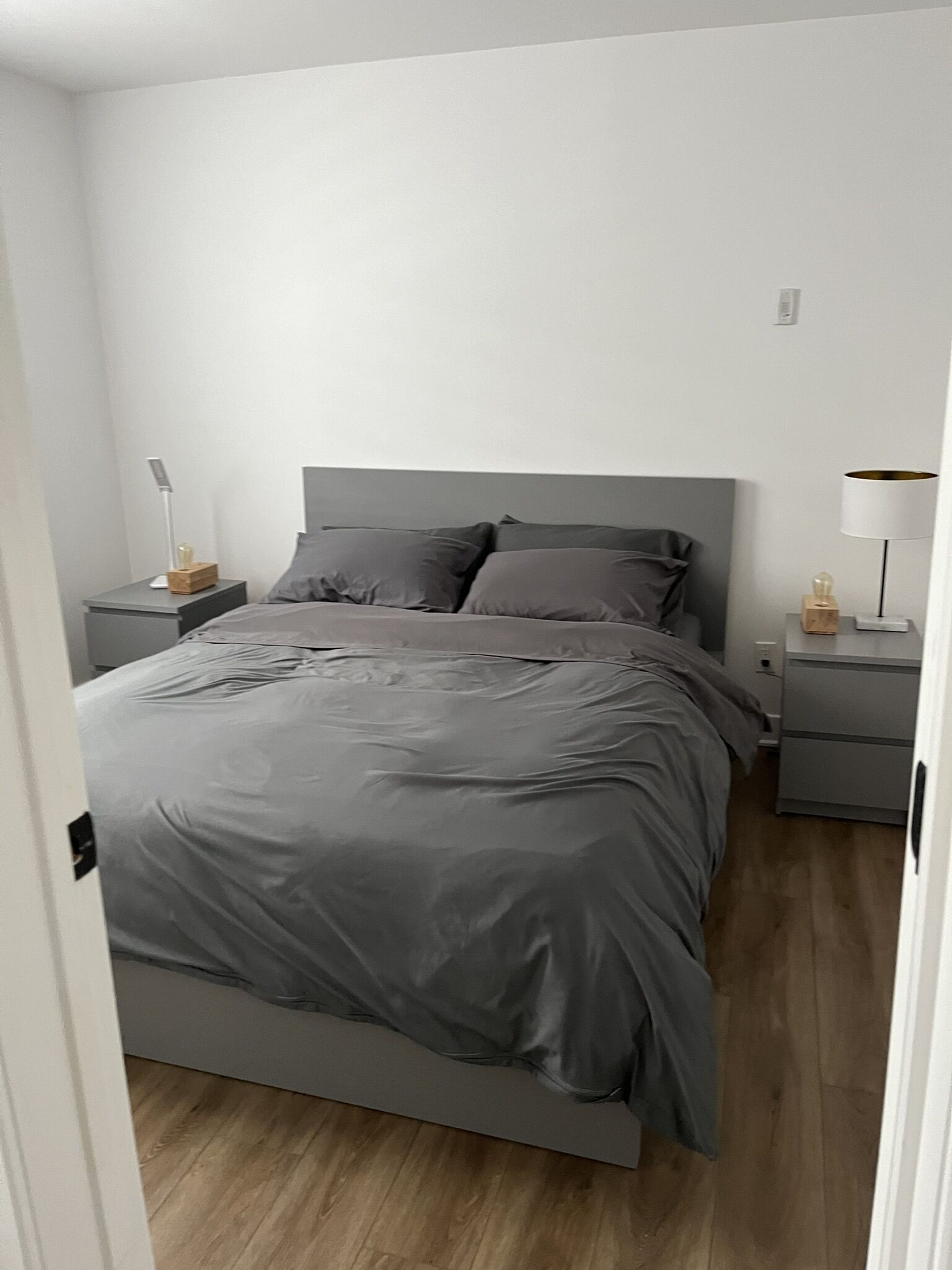A bedroom with a bed, two bedside tables, and a nightstand.