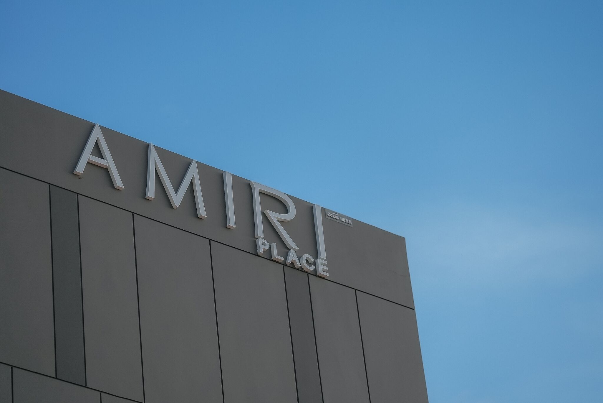 A building with the sign "AMIRI PLACE" on its facade.