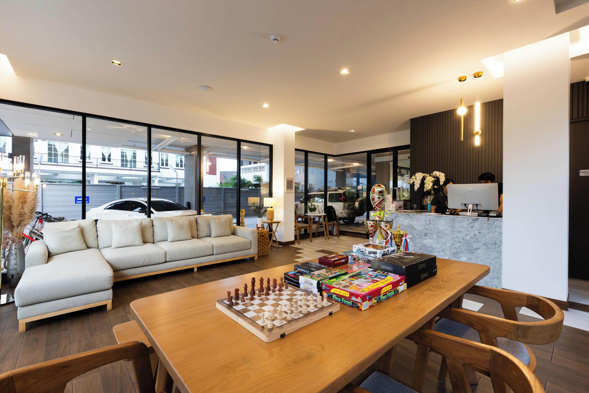 A modern living room with a wooden table, a sofa, and a chessboard.