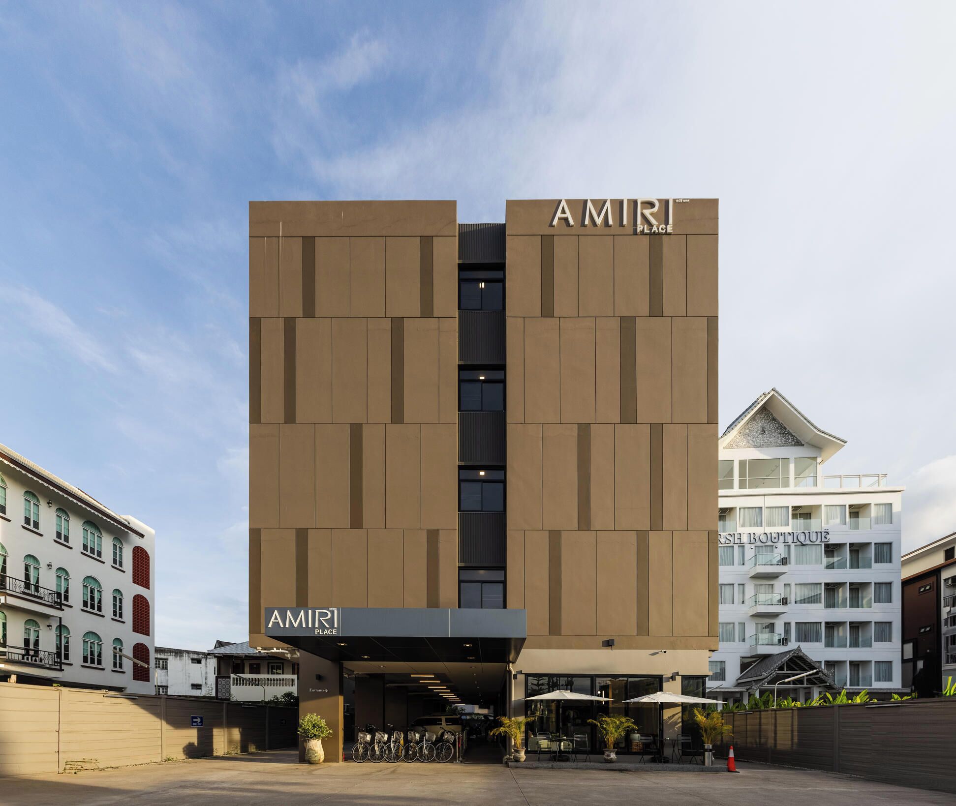 Ein modernes Gebäude mit der Aufschrift 'AMIRI PLACE' an der Fassade.