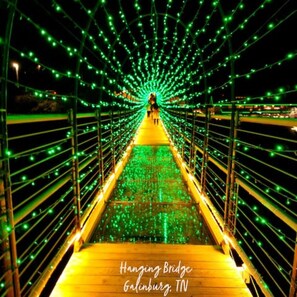 A pedestrian bridge with green lights and a wooden walkway. - New Listing! Boutique Studio Close to Downtown - First 3 Bookings Get 20% Off  (Knoxville)