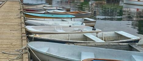 A wooden pier with several small boats docked at a marina.