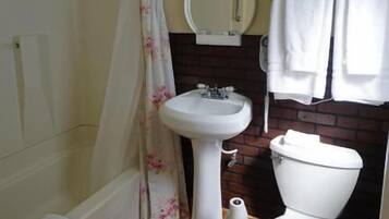 A bathroom with a bathtub, a sink, a toilet, and a shower curtain.