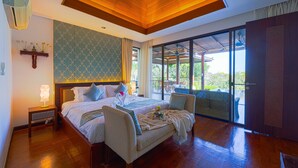 Een ruime slaapkamer met een groot bed, houten plafond, uitzicht op de omgeving en een balkon.