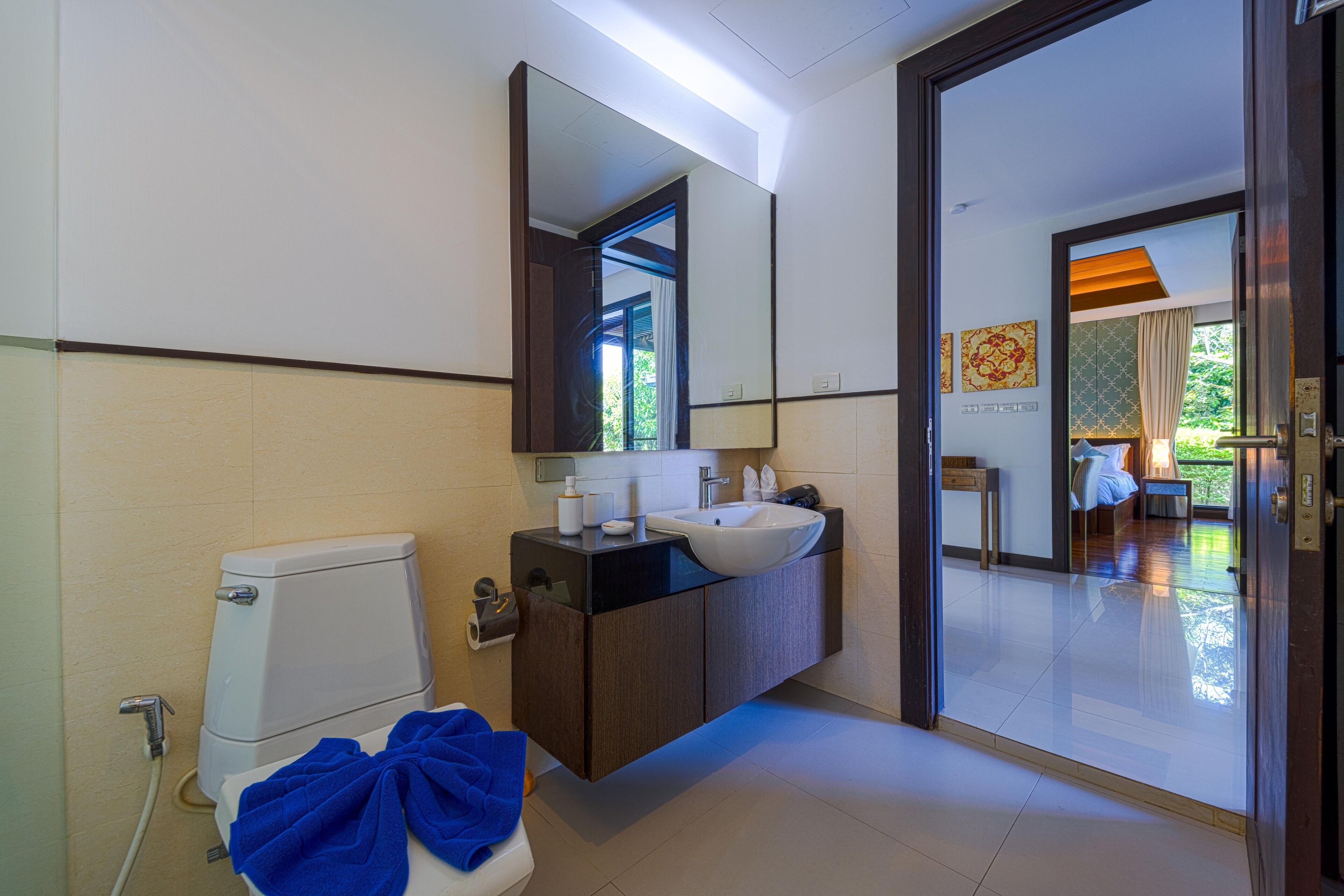 A modern bathroom with a toilet, sink, and mirror.