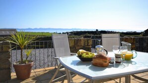 Ein Tisch mit Frühstücksangeboten und Blick aufs Meer.