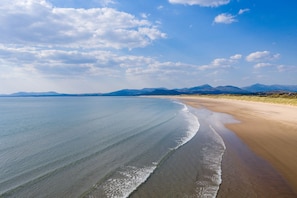 A beach with a clear sky and distant mountains.
