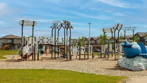 A playground with climbing structures and a large blue sculpture.