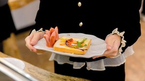 Une personne tenant une assiette avec un sandwich et de la viande.